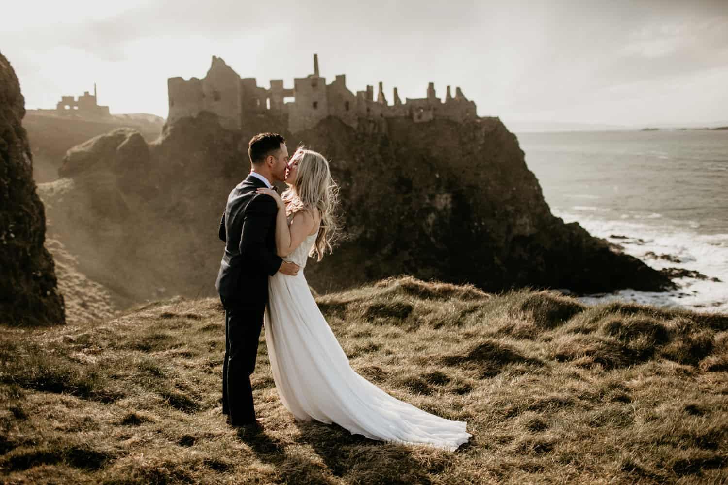 Couple overlooking Dunluce Castle cliffs
